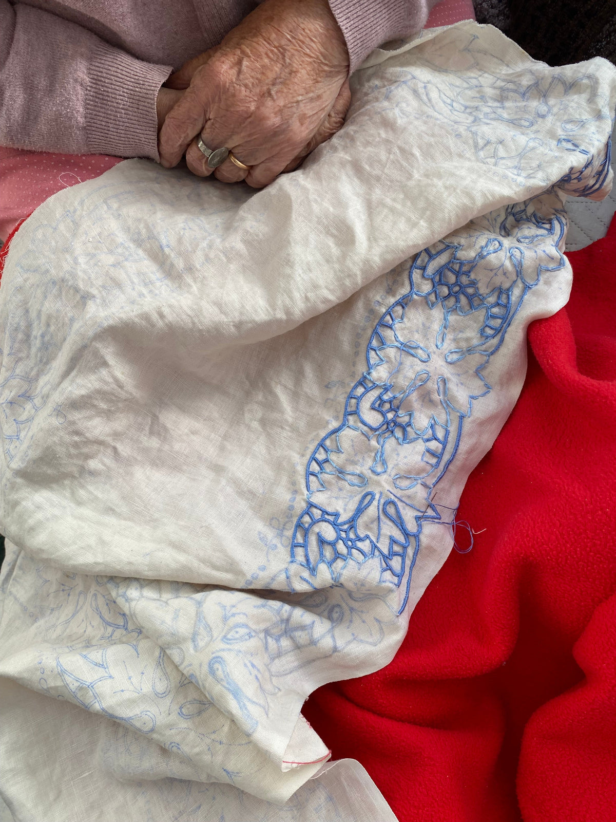 Traditional Madeira embroidery resting on a woman's lap.