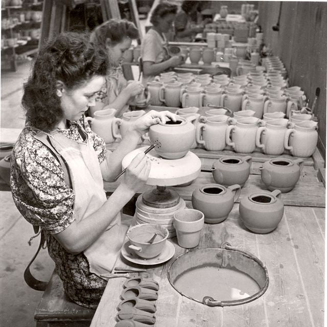 Woman crafting ceramic teapots by hand at the Rörstrand factory in Sweden.